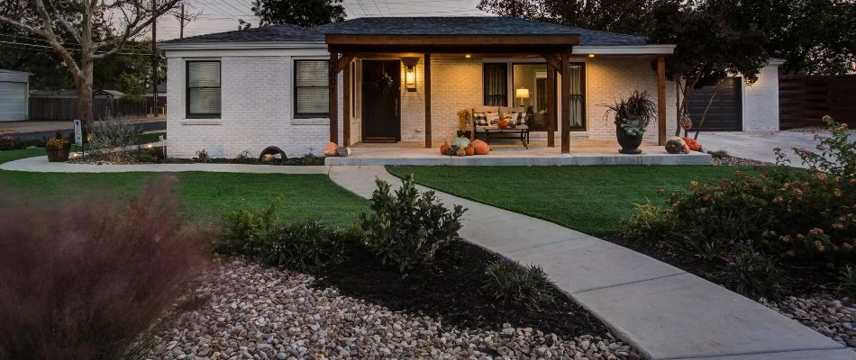 Mulched landscape and green lawn in Idalou, TX, by a house.