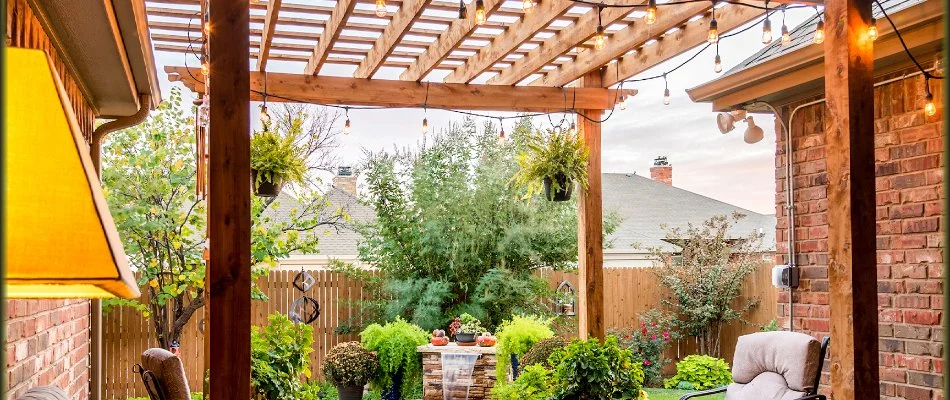 Wooden pergola and lush plantings in an outdoor space in Post, TX.